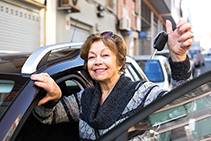 Female driver 60-75 years old  standing with car key outdoor